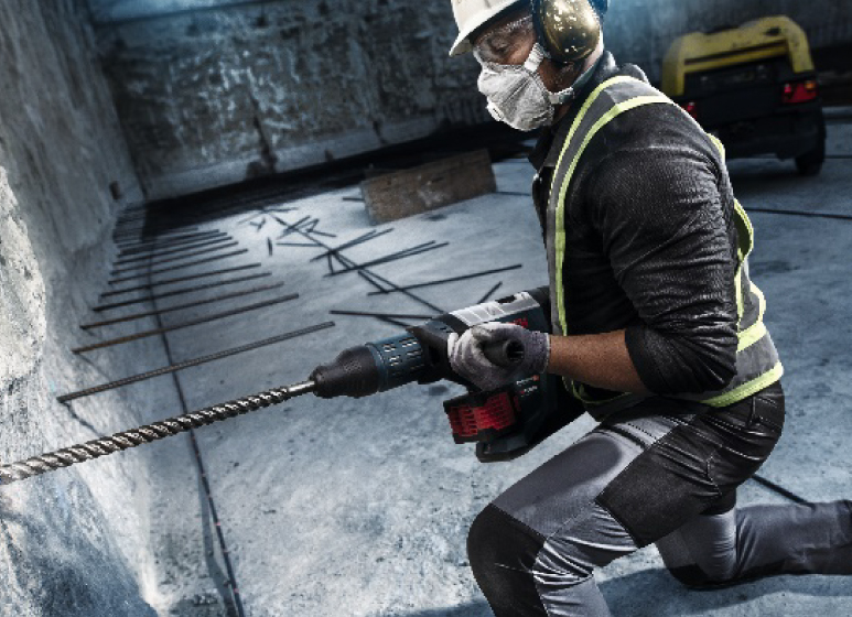 Bauarbeiter mit Bosch Bohrhammer bei schwerer Betonbearbeitung