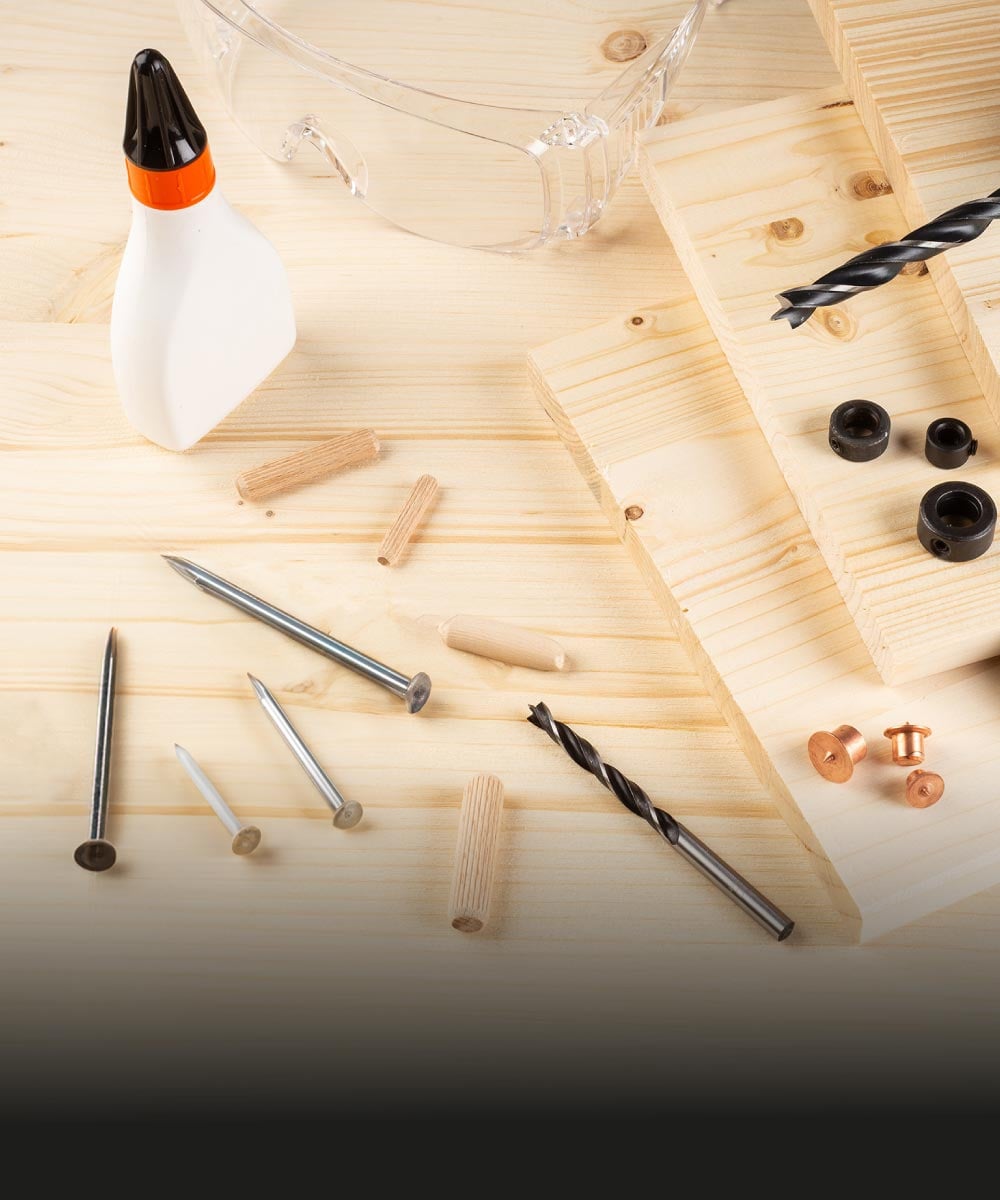 Werkzeuge, Dübel, Nägel und Holzmaterialien auf einem Tisch