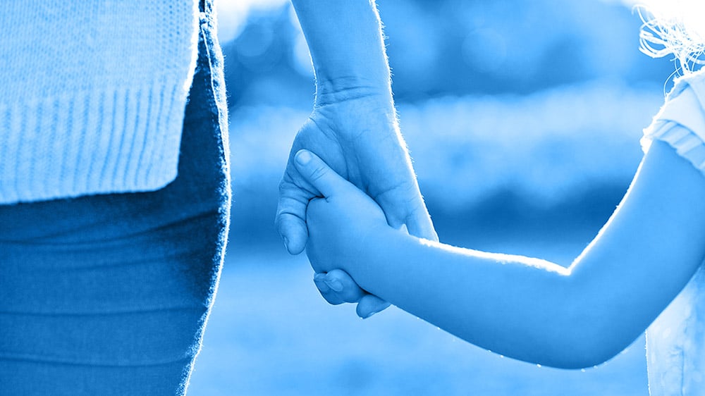 Röhm Symbolische Darstellung von Vertrauen – Erwachsener hält die Hand eines Kindes Röhm Erwachsene Hand hält die Hand eines Kindes – Symbol für Vertrauen und Sicherheit