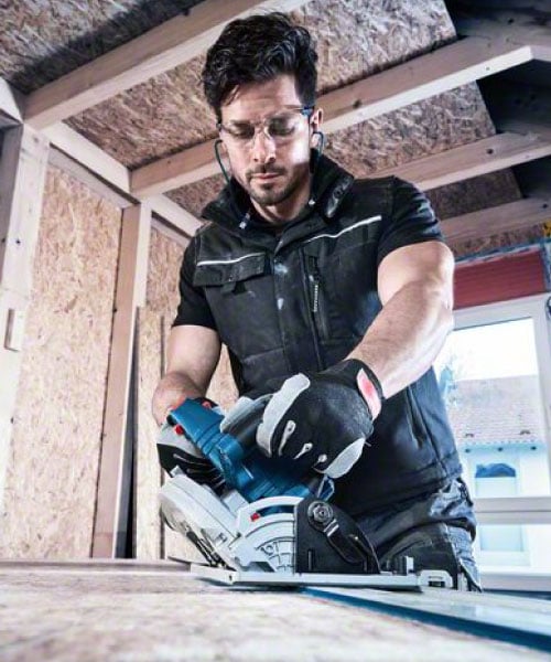 Handwerker verwendet Bosch Biturbo Kreissäge auf einer Holzplatte