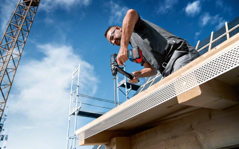 Handwerker auf einer Baustelle verwendet einen Bosch Akku-Bohrschrauber GSB 18V-150 C