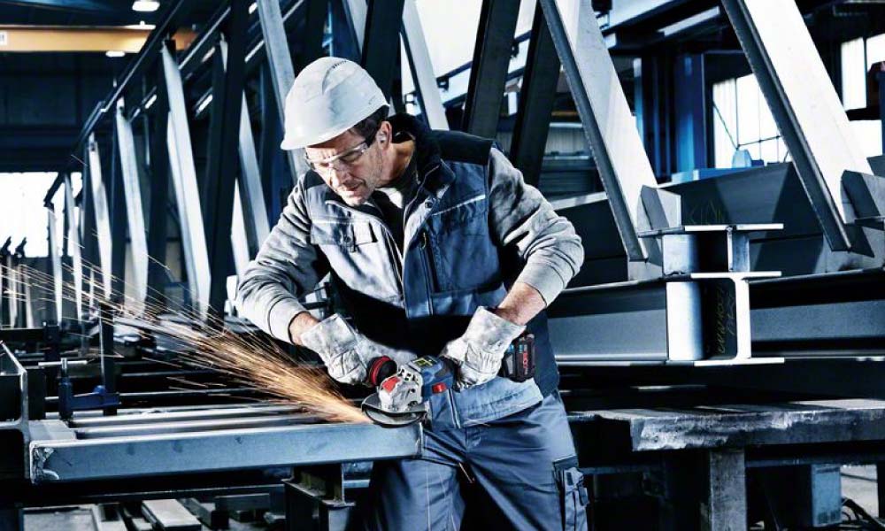 Handwerker arbeitet mit Bosch BITURBO Winkelschleifer und erzeugt Funken beim Schneiden von Metall