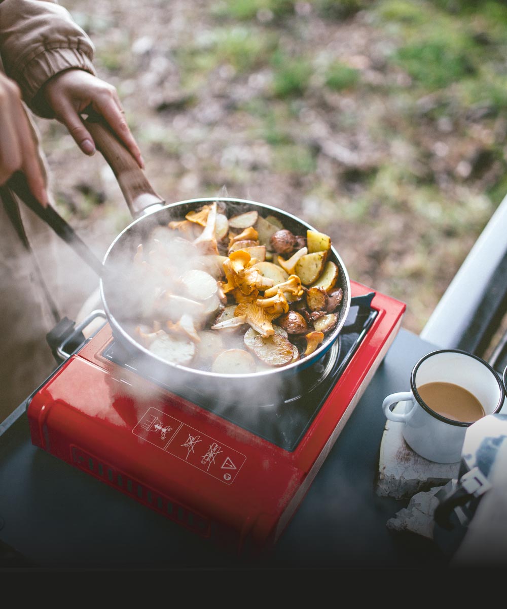Kochen auf einem Campingkocher im Freien