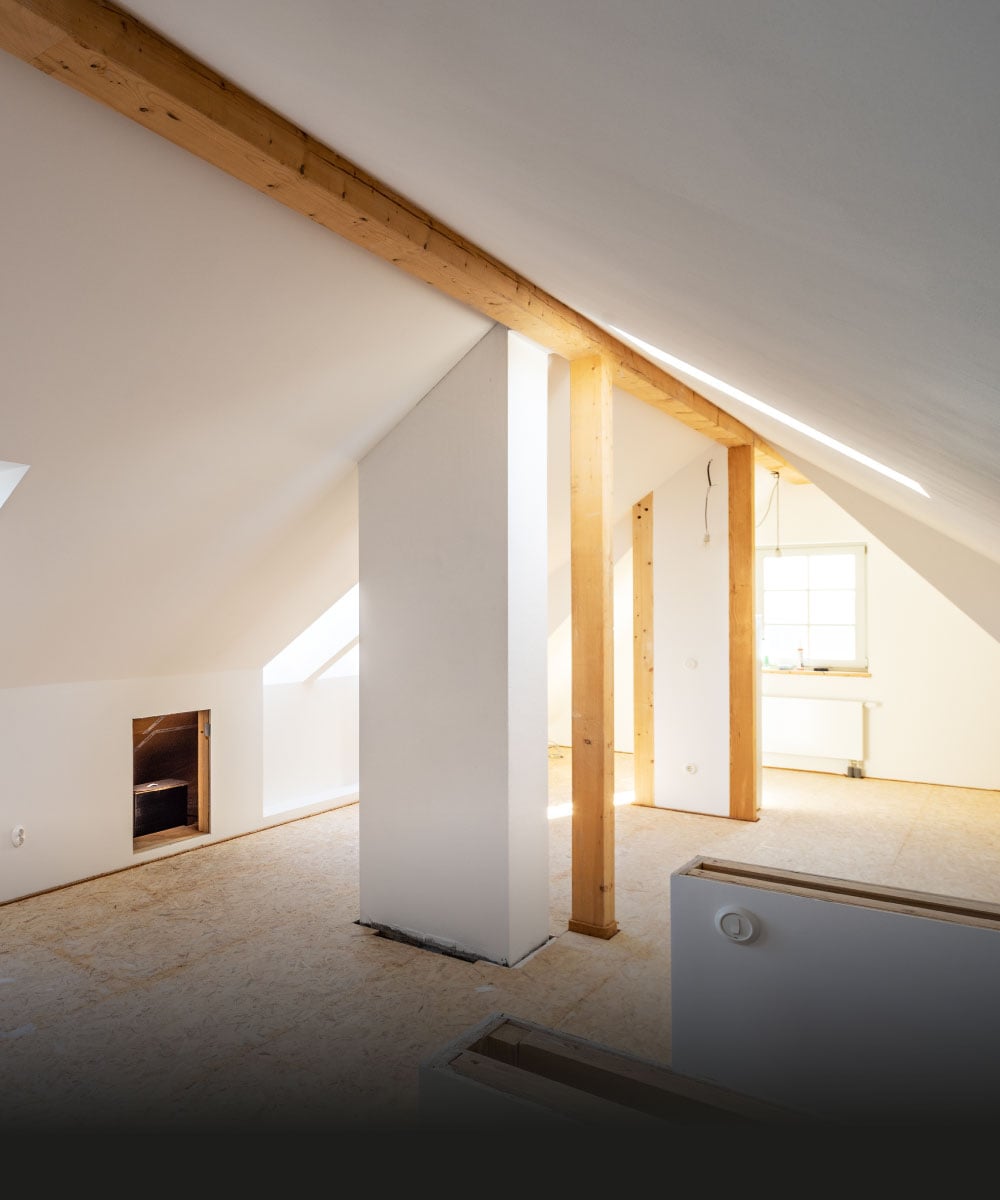 Leeres Dachgeschoss mit Holzbalken und natürlichem Licht