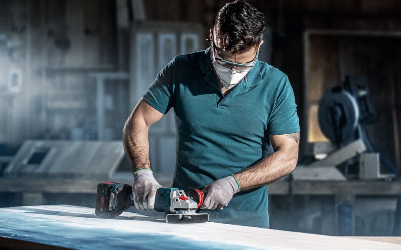 Handwerker schleift Holzoberfläche mit Bosch ProCORE 18V Winkelschleifer