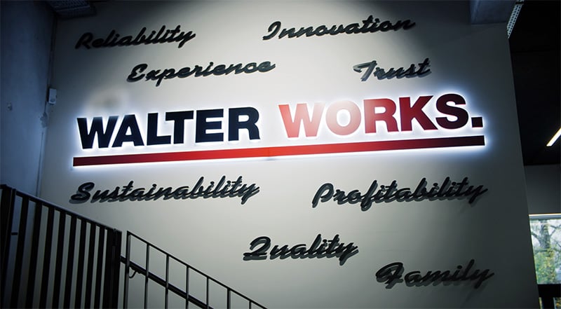Walter Works Unternehmenswerte: Innovation, Vertrauen, Nachhaltigkeit und mehr "Walter Works Logo an einer Wand mit Unternehmenswerten wie Innovation, Vertrauen und Nachhaltigkeit