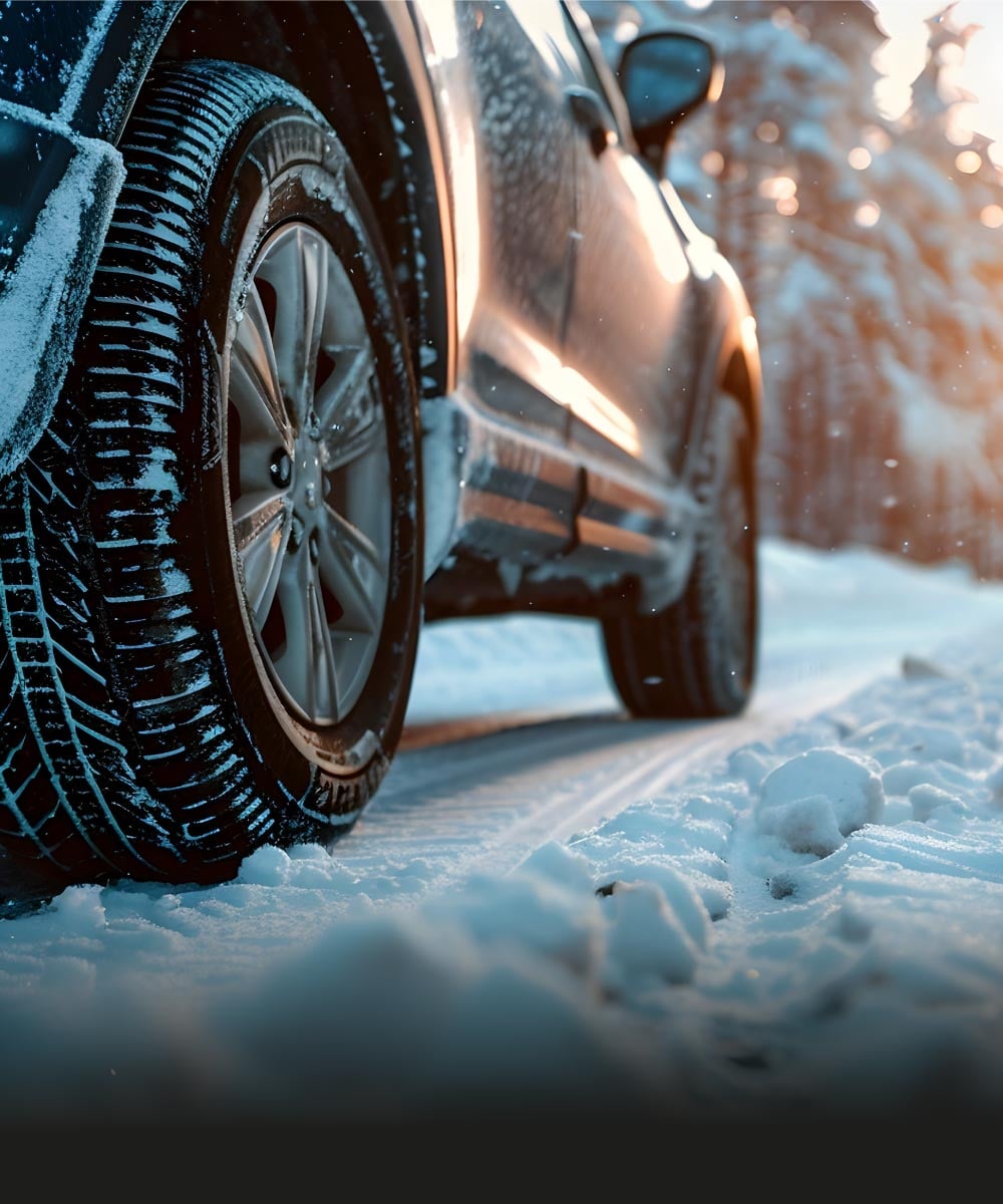 Auto auf verschneiter Straße mit Winterreifen